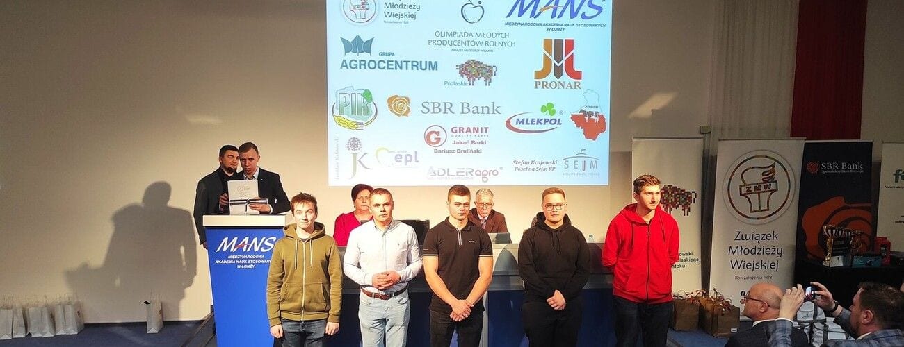 Uczestnicy Olimpiady Młodych Producentów Rolnych na scenie przed planszą partnerów wydarzenia.