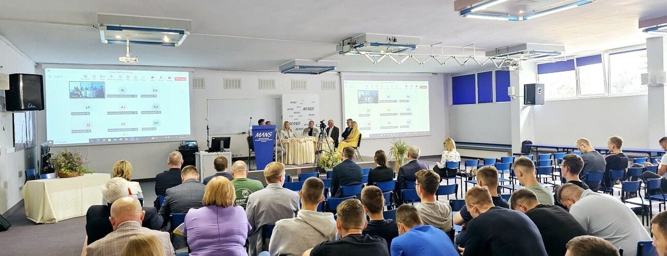 Uczestnicy kongresu rolnictwa regeneratywnego i ekologicznego w auli z dwoma ekranami prezentacyjnymi.