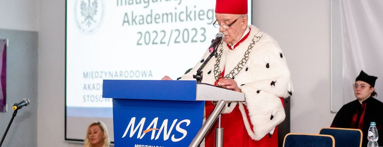 Osoba w stroju rektorskim przemawia przy mównicy MANS podczas inauguracji roku akademickiego 2022/2023.