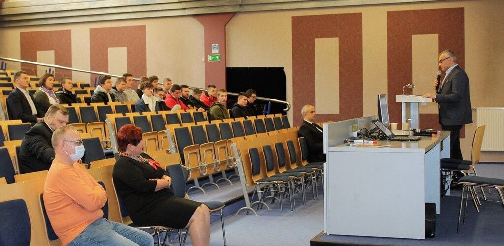 Prelegent przy mównicy i uczestnicy konferencji COBORU w sali wykładowej.