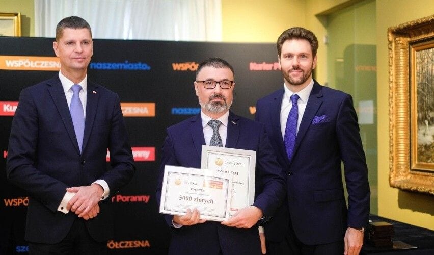 Trzej uczestnicy uroczystości prezentujący dyplomy i nagrodę w plebiscycie edukacyjnym.