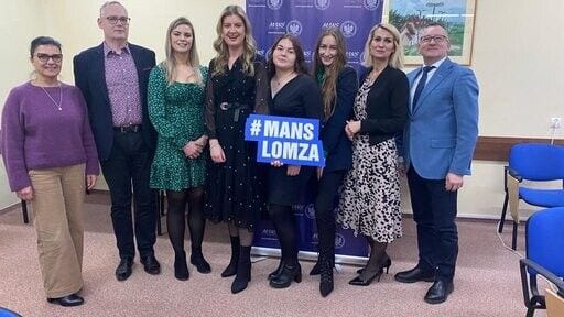 Uczestnicy konferencji DigiFE pozujący z tabliczką „MANS Łomża”.