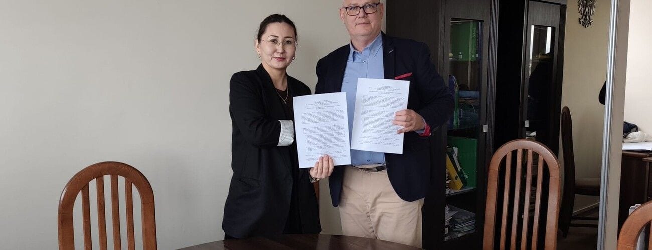 Kobieta i mężczyzna prezentujący otwarte dokumenty porozumienia w biurze.