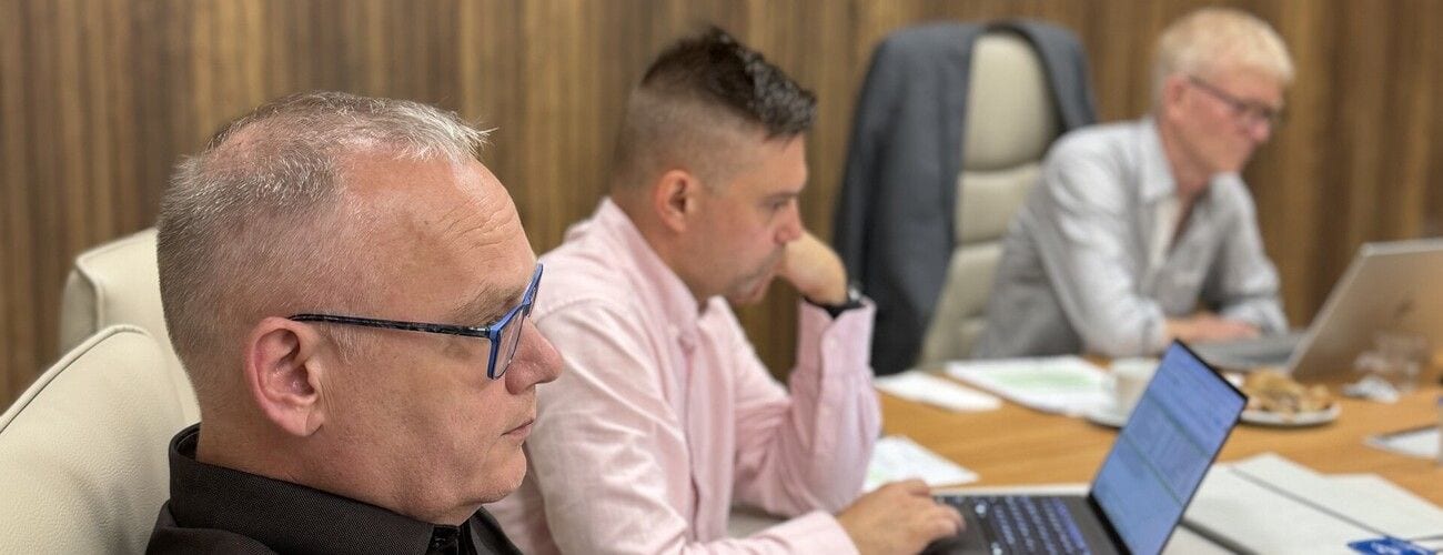 Uczestnicy spotkania projektu AgriVOLTages w Bursie przy stole konferencyjnym z laptopami.
