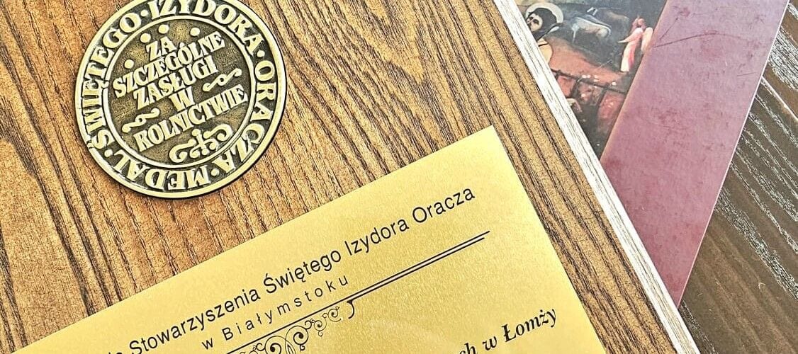Pamiątkowa tablica z medalionem św. Izydora Oracza i grawerowanym napisem.