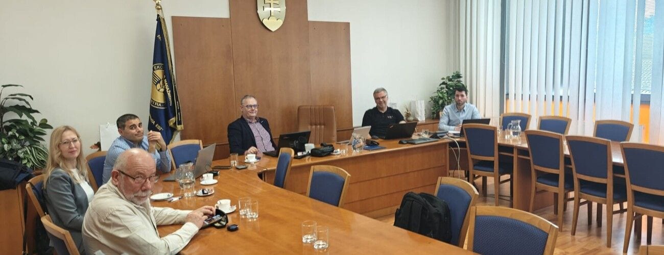 Zespół podczas spotkania roboczego przy stołach w sali konferencyjnej.