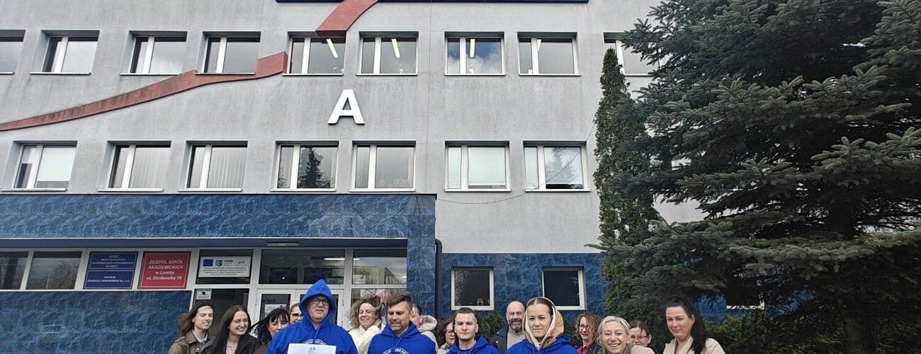 Uczestnicy wydarzenia pozujący przed budynkiem MANS oznaczonym literą A.