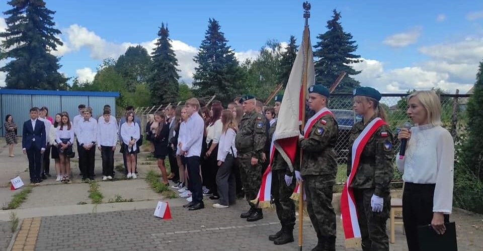 Uczniowie i poczet sztandarowy podczas plenerowej inauguracji roku szkolnego.