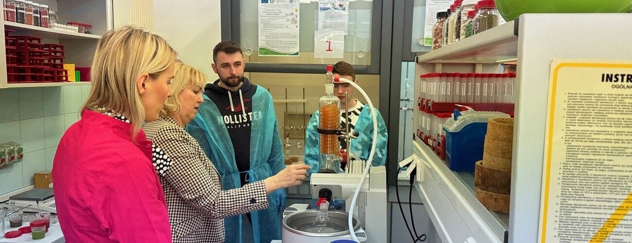 Uczestnicy wizyty w Instytucie Ochrony Roślin oglądający aparaturę laboratoryjną.