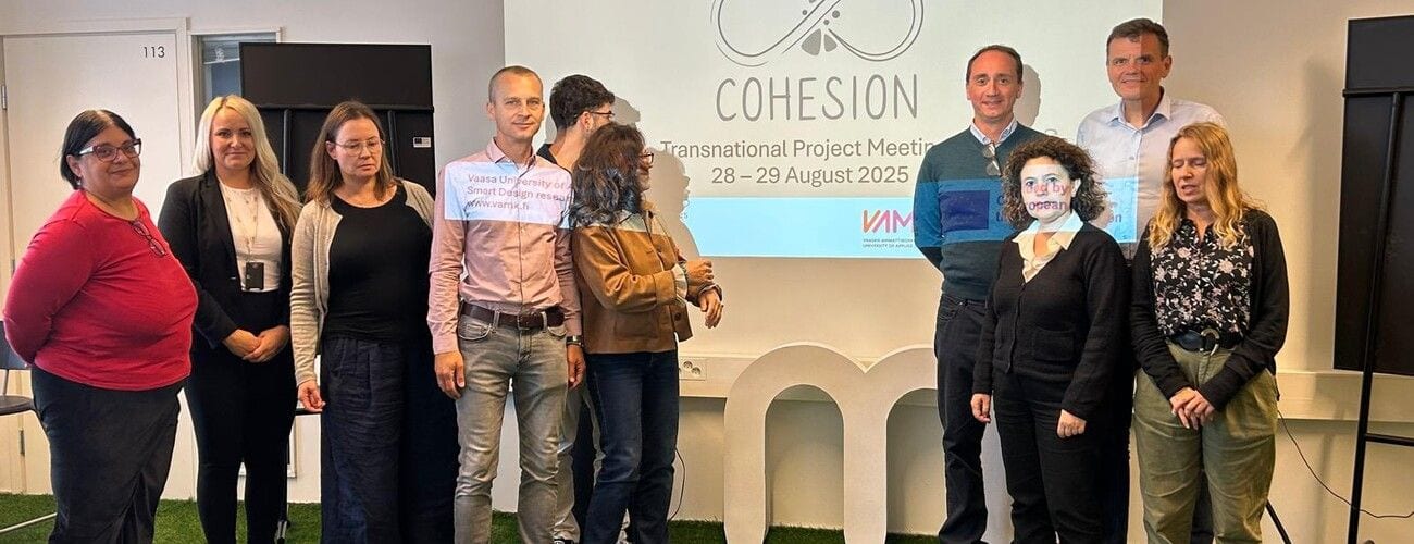 Uczestnicy spotkania COHESION pozujący na tle planszy z nazwą projektu i datą 28–29 sierpnia 2025 r.