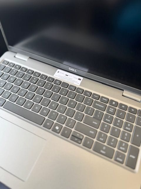 Otwarty laptop Dell z klawiaturą i panelem dotykowym.