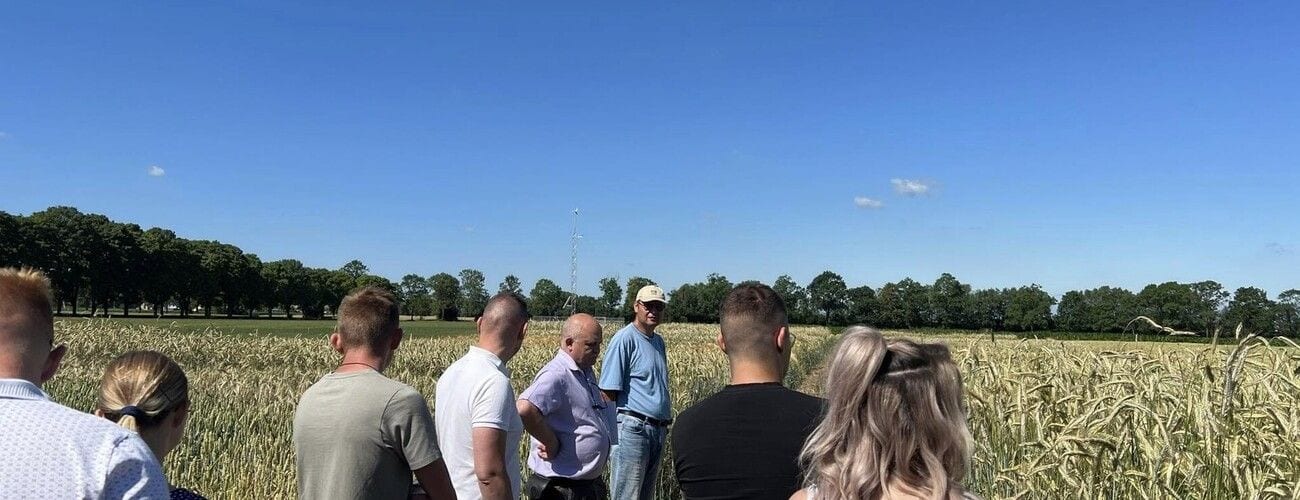 Grupa zwiedzająca pola uprawne podczas wizyty w ośrodku doradztwa rolniczego w Szepietowie.