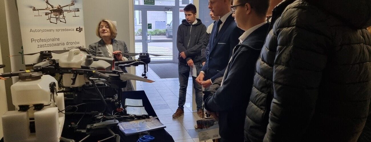 Uczestnicy konferencji oglądający urządzenia i drony podczas pokazu.