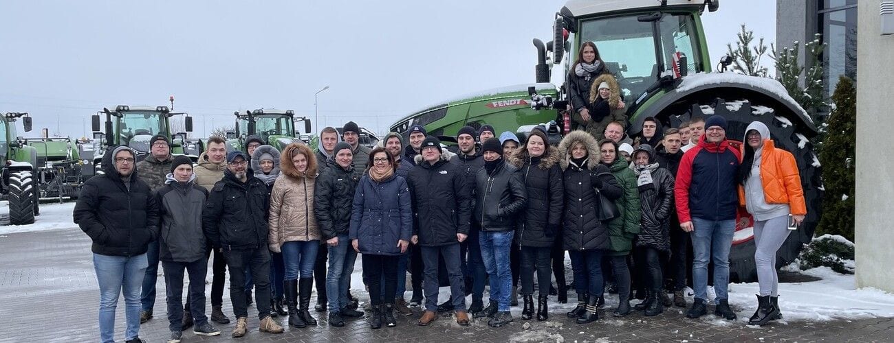 Uczestnicy zajęć praktycznych przy ciągniku na zaśnieżonym placu firmy Agrotechnik Tafiły.