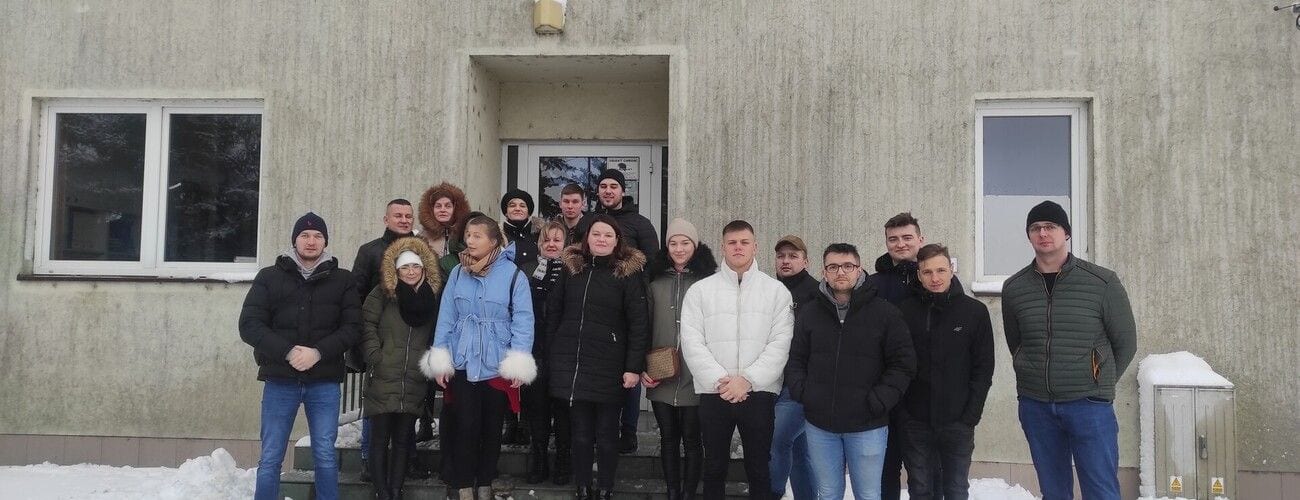 Grupa studentów i prowadzących przed budynkiem oczyszczalni ścieków.